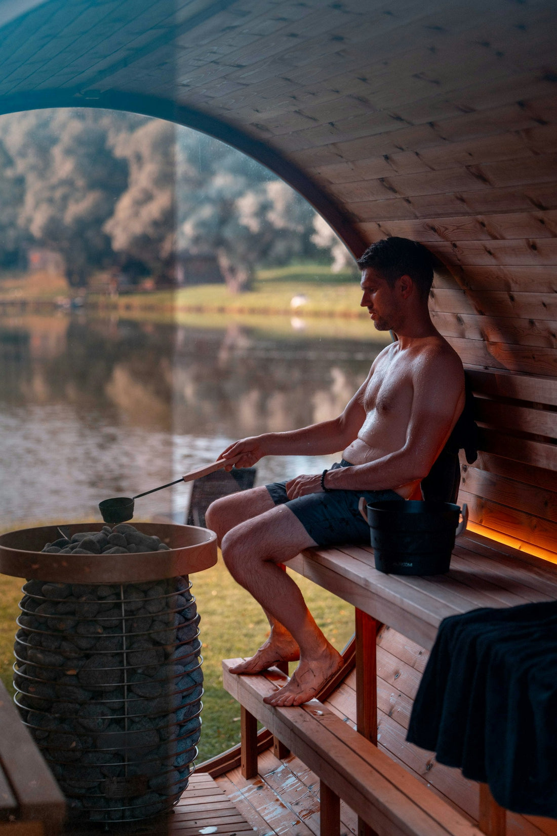 Ladle pouring water onto hot sauna stones to make löyly steam